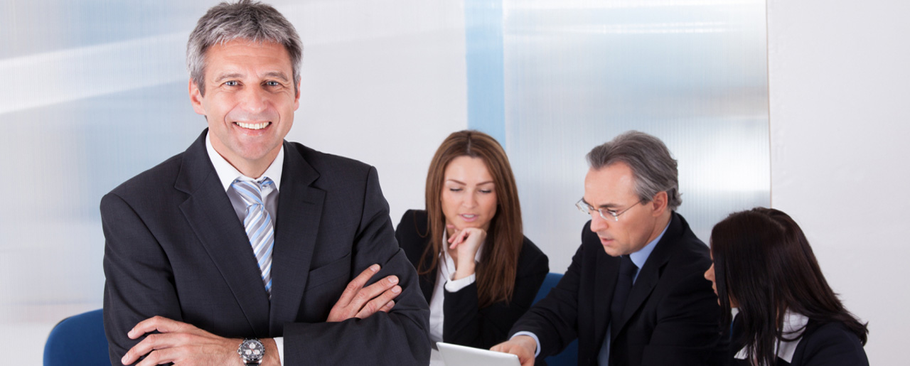 Businessman Standing In Front Of Colleagues
